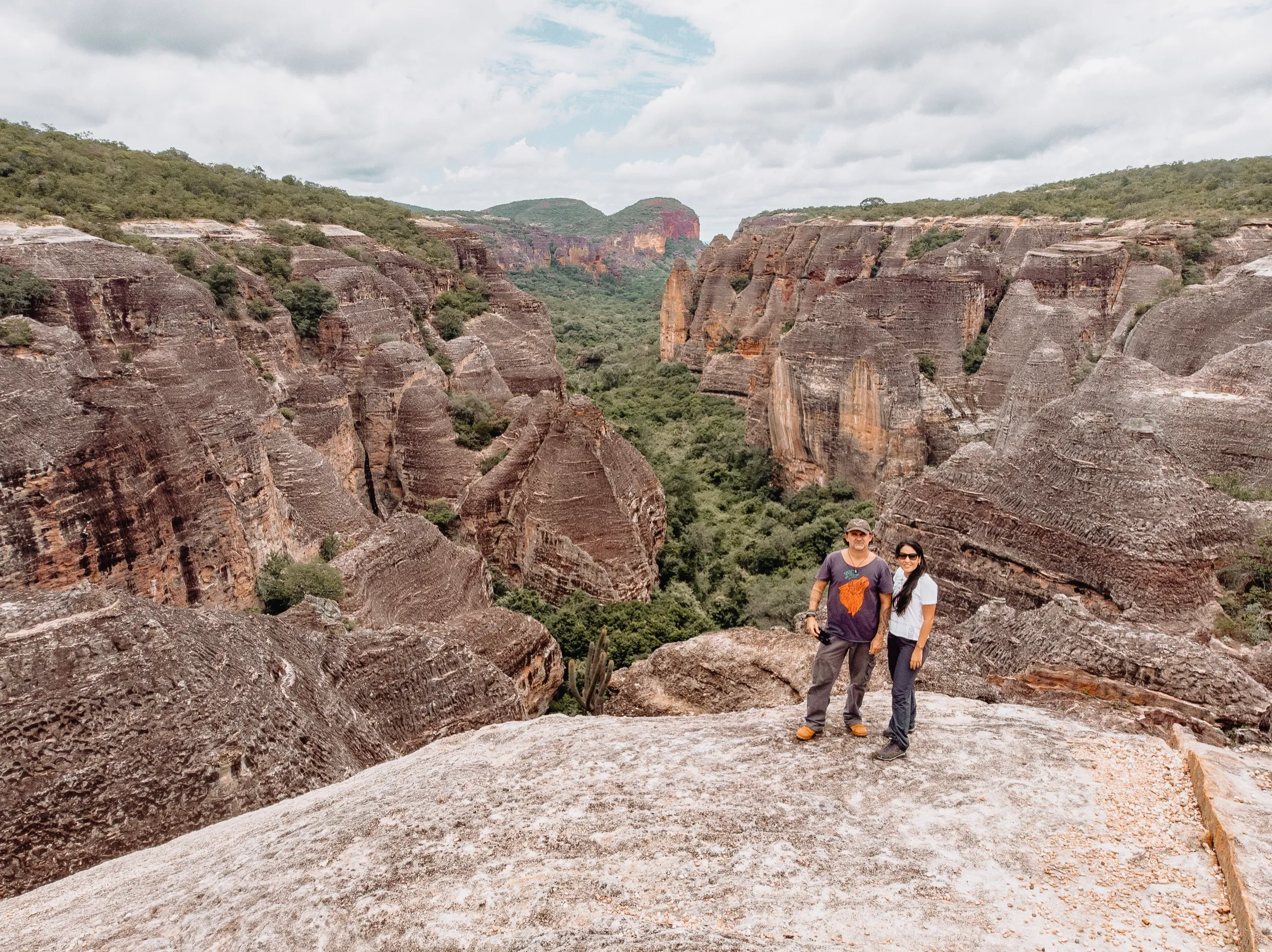 Vista aérea de um cânion de arenito, com dois integrantes da Barong no alto da rocha